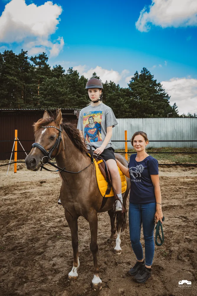 Nastoletni uczeń na koniu z instruktorką w stajni Shergar