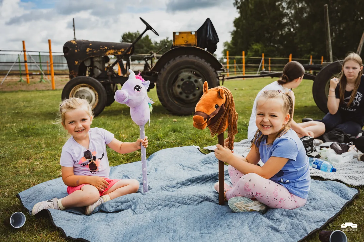 Dzieci bawiące się hobby horse na pikniku podczas półkolonii w stajni Shergar